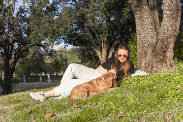 Cocker spaniel enjoys loving moment with woman owner in outdoor park setting during daytime