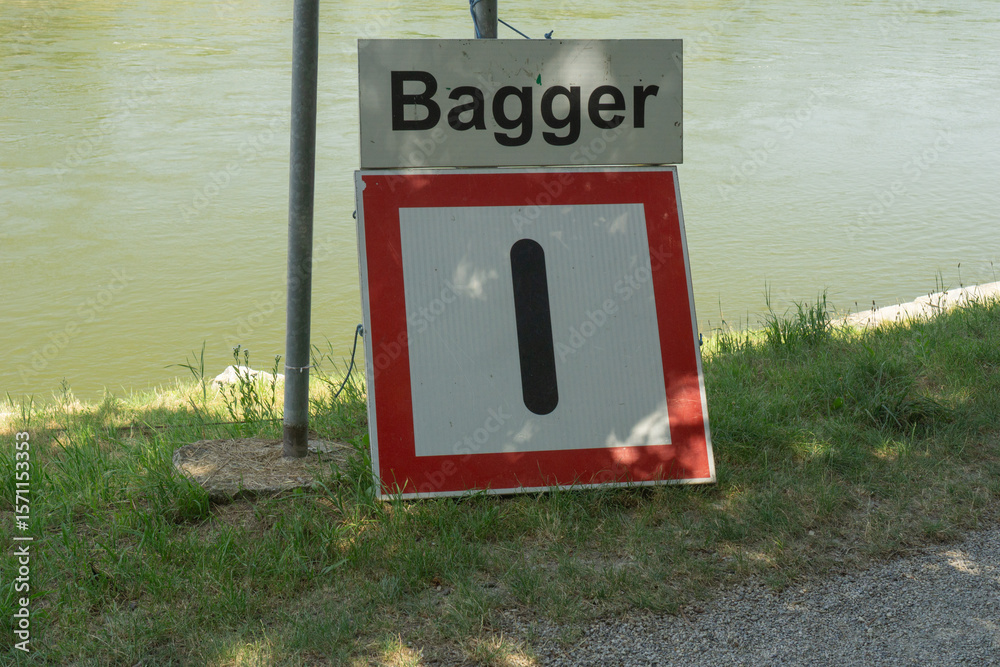 Fototapete bagger sign with number one below it by a river, indicating a specific point or warning, suitable fo