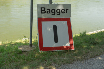 Bagger sign with number one below it by a river, indicating a specific point or warning, suitable...