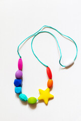Colorful silicone teether necklace in the form of a rodent on a white background