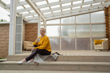 A Relaxing Outdoor Space Featuring a Woman Who Is Happily Enjoying a Refreshing Beverage