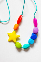 Colorful silicone teether necklace in the form of a rodent on a white background
