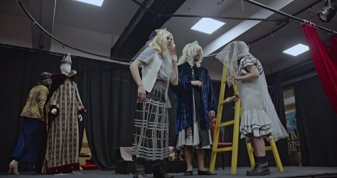 Actors rehearse a play on stage, demonstrating collaboration, creativity, and dedication to their craft. They prepare for a captivating performance.
