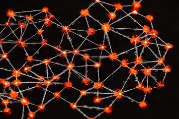 Abstract network of interconnected orange lights on a dark background.  Intricate web of luminous points connected by thin threads
