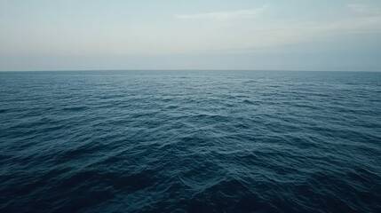 Obraz premium Serene Ocean Vista: Deep Blue Waters Under a Pale Sky