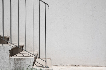 Modern concrete staircase against a white wall.