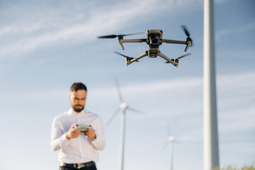Focused photo of flying drone. Engineer in field checking on wind turbine production