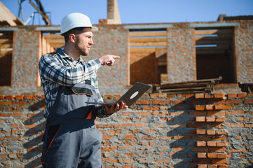 Installing brick wall. Construction worker in uniform and safety equipment have job on building