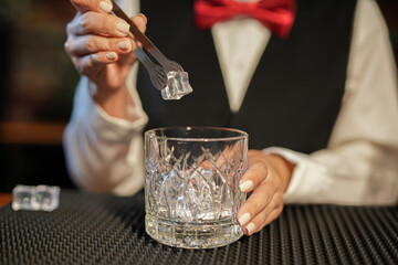 Professional female bartender preparing alcoholic drinks in a bar