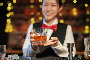 Professional female bartender preparing alcoholic drinks in a bar