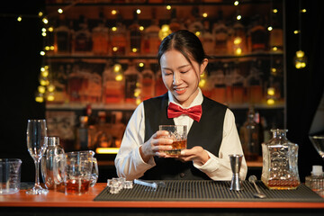 Professional female bartender preparing alcoholic drinks in a bar