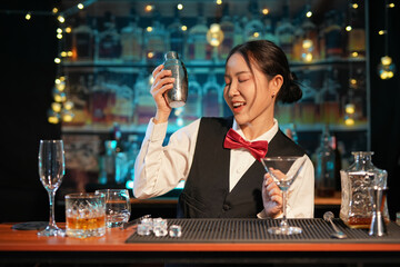 Professional female bartender preparing alcoholic drinks in a bar