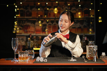 Professional female bartender preparing alcoholic drinks in a bar