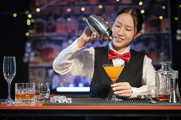  Professional female bartender preparing alcoholic drinks in a bar