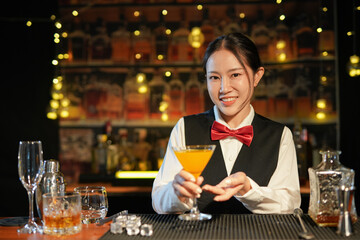 Professional female bartender preparing alcoholic drinks in a bar