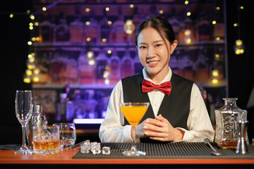 Professional female bartender preparing alcoholic drinks in a bar