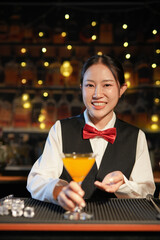 Professional female bartender preparing alcoholic drinks in a bar