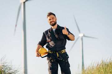 Thumb up hand gesture. Engineer in field checking on wind turbine production