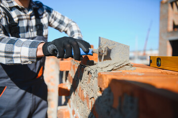 Portrait of a builder in the process of working on a construction site outdoors