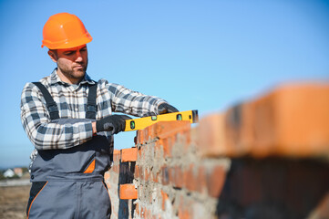 Portrait of a builder in the process of working on a construction site outdoors