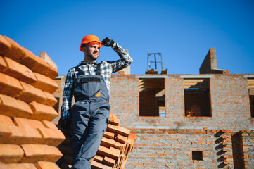 construction mason worker bricklayer installing red brick with trowel putty knife outdoors