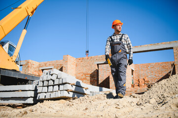 Installing brick wall. Construction worker in uniform and safety equipment have job on building