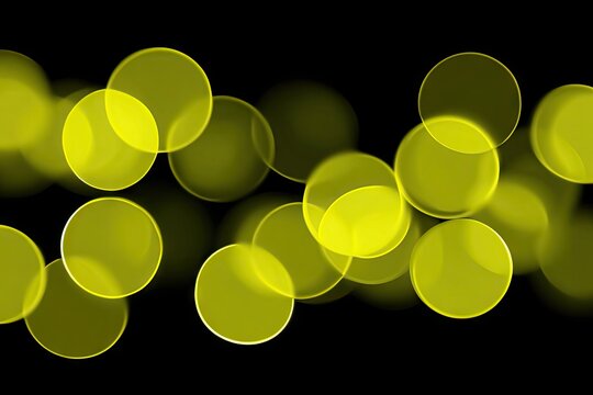 Abstract bokeh circles of bright yellow light on a black background