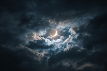 a crescent is seen in the sky with a dark cloud