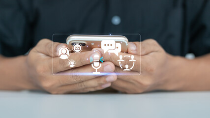 Close-up of hands using smartphone with virtual icons of chat, voice message, email, and social...