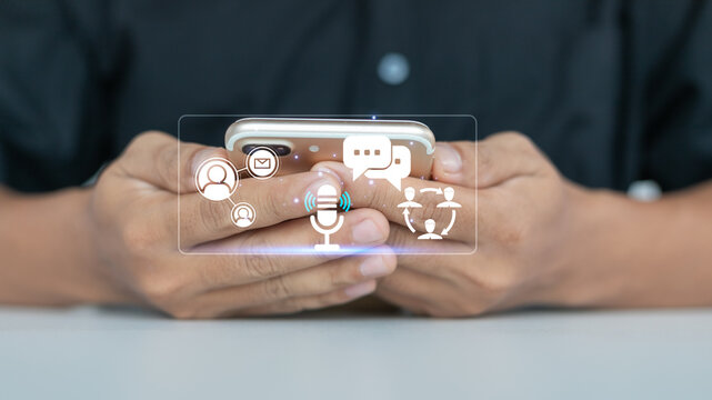 Close-up of hands using smartphone with virtual icons of chat, voice message, email, and social network, representing digital communication and social media connection.