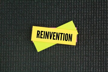 colored paper with the word Reinvention. the action or process through which something is changed...