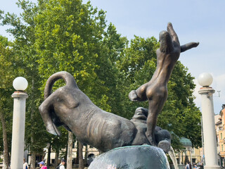 Ljubljana, Slovenia - July 06, 2025: Bronze sculpture of a woman dancing joyfully with a dog in a...