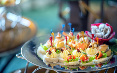 A variety of canapes on a silver platter.