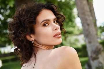Charming young woman enjoying a sunny summer day in a lush green park setting
