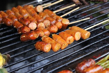 grilled pork sausages on charcoal stove – thai street food close-up
