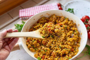 Chickpea curry with rice and vegetables fresh and homemade cooked in a frying pan on decorated background