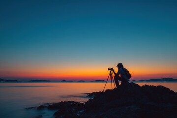 Outline of a photographer capturing a stunning sunset on a rocky beach during twilight