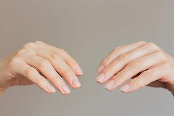Close-up comparison before and after of a well-groomed female hands with a beautiful delicate fashionable nude manicure. Beauty and hand care