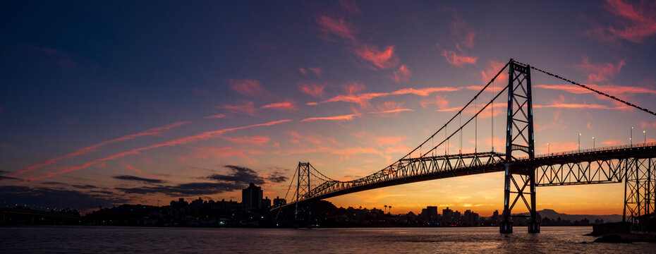 Fototapeta panoramic view of the sunset with the multicolored sky and the Hercilio Luz bridge postcard of the city of Florianópolis capital of the State of Santa Catarina Brazil