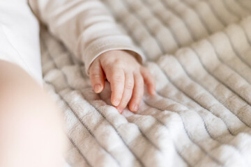 Infant Hand Resting on Soft Blanket