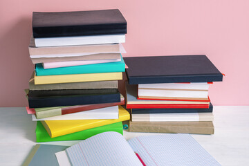 Two stacks of colorful books on white rustic tables. Back to school concept. Copy space