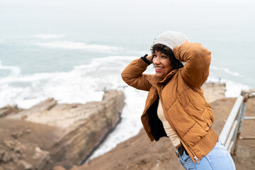 Happy woman enjoying ocean view on cold winter day