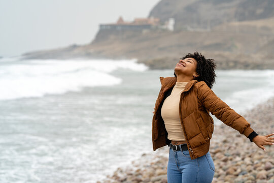 Young woman enjoying fresh air on the beach, changing routine