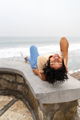 Young woman lying down and enjoying the seaside view