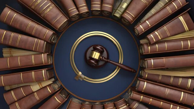 Overhead view of gavel in gold rings surrounded by books on a blue background in a studio shot. Gavel and law books. Symbol of justice and law. Legal authority concept. Courtroom representation