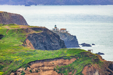 Scenic view of Point Bonita Lighthouse perched on a dramatic cliff along the Marin Headlands, overlooking the Pacific Ocean under soft coastal light