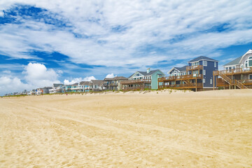Yellow sand and Rows of beach houses on stilts in Avon, North Carolina.