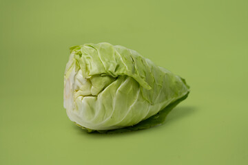 Fresh Green Cabbage on Vibrant Green Background Showcasing Raw Vegetables