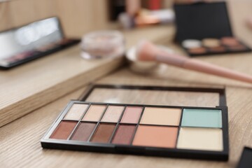 Palette with eyeshadows and color correctors on vanity indoors, closeup