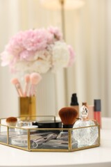 Tray with different makeup products on white table indoors, closeup